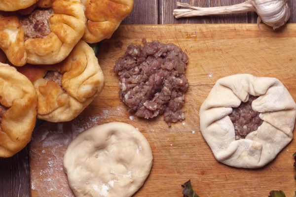 homemade open meat pies, belyashi. on wooden background.