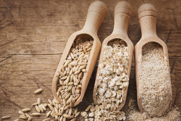 Oat flakes, seeds and bran in spoons