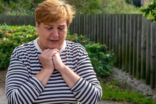 Mature woman in striped shirt walks in city Park