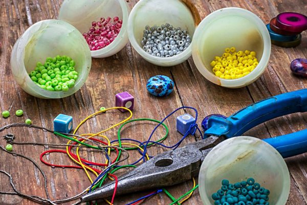 coil,beads and tools for needlework on turquoise wooden background