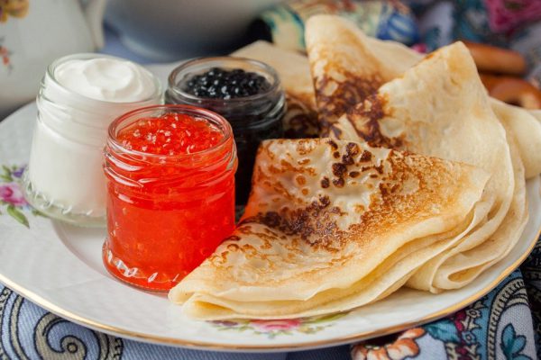 Pancake with red caviar and tea during Shrovetide