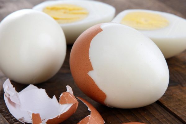 Peeled boiled egg on wooden background