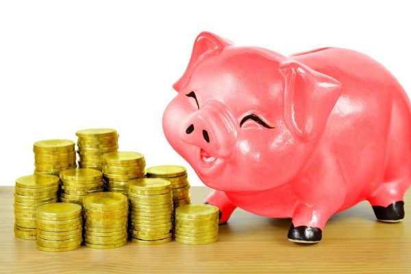 Pink piggy bank and gold coins on wood table isolated on white background with clipping path.