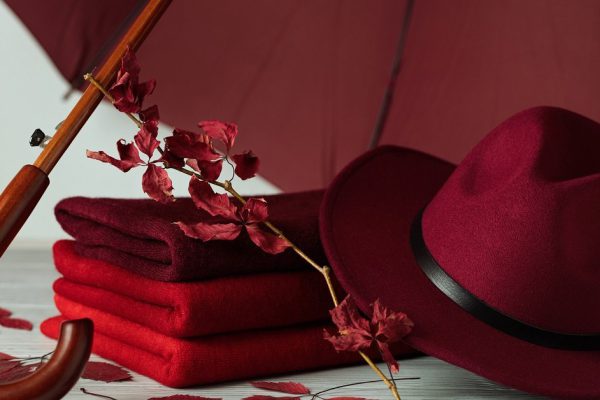 Fashion trend autumn winter. Clothing (sweaters) of different shades of red and crimson. Selective focus.