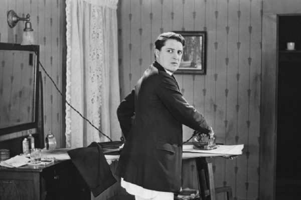 Man in sock garters ironing