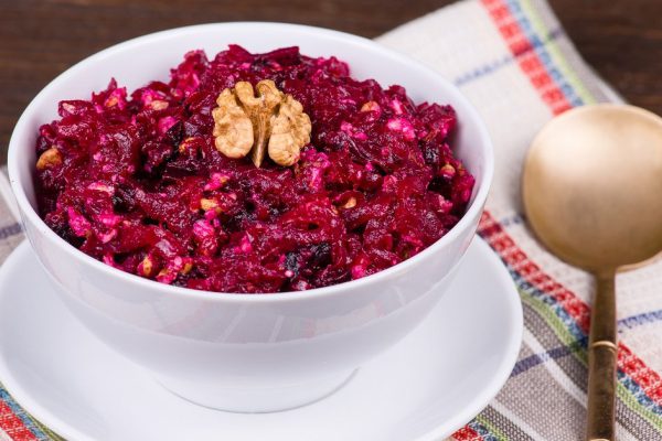 Fresh salad with beet and walnuts on white plate