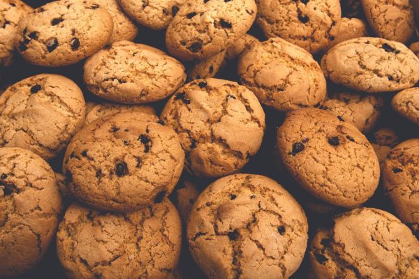 Cookies background. Sweet chocolate chips biscuits and cookies texture background. Oatmeal, chocolated drops and other sweets. Dessert, sweets for tea. Fattening sweets concept