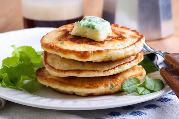 Sweetcorn pancakes with herb butter on plate