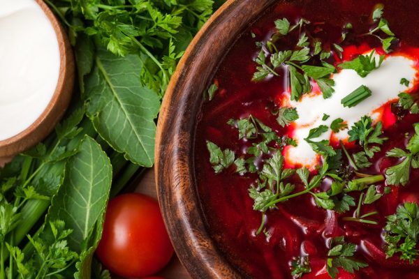 Borsch in a wooden plate with a sour cream