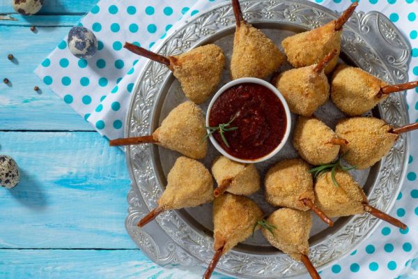 Spicy roast quail legs, a cutlet in a batter with a breaded on a wooden table. Top view, copy space.