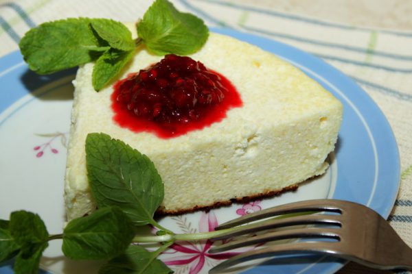 Cottage cheese souffle with raspberry jam and a sprig of mint on the plate