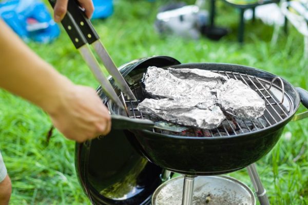 Grilling meat with barbecue stuff. Horizontal close up shot with a selective focus