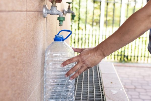 The man pours clean drinking water into the bottle.