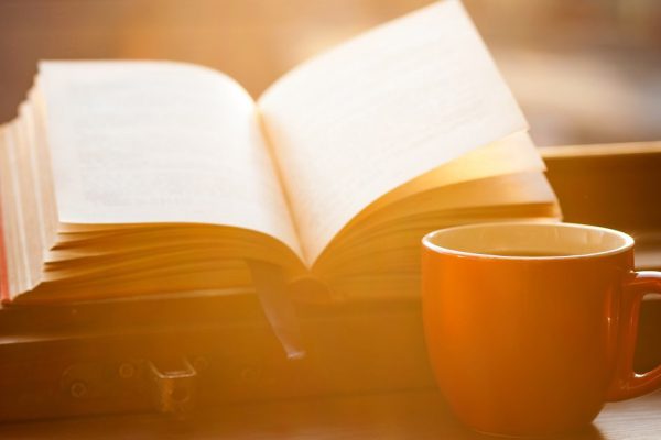 Books and a coffee cup on a windowsill