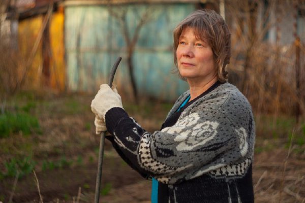 Woman digging the beds at the cottage and plants