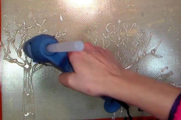 Этот мужчина выливает горячий клей на пергаментную бумагу. Когда он высохнет, ты будешь в восторге!