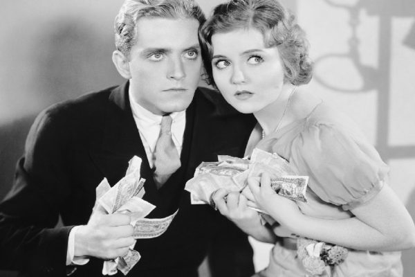 Couple looking scared with a fistful of money