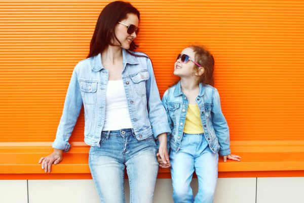 Happy mother and child wearing a jeans clothes in city