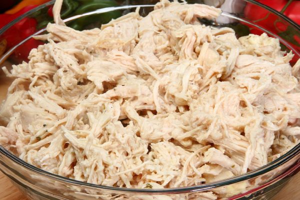 Bowl of shredded chicken breast in bowl in kitchen or restaurant.