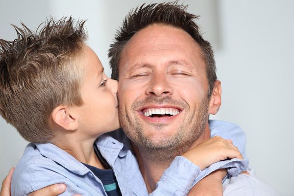 Little bond boy giving a kiss to his dad