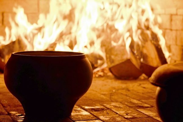 Traditional Russian stove with cooking food on wood in crock. Pot in fireplace. Russian cuisine concept