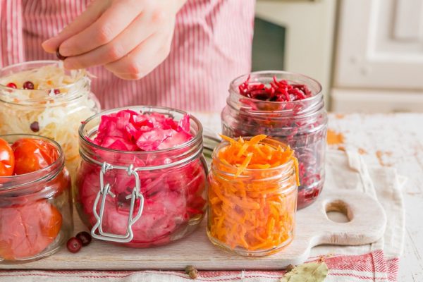 Selection of fermented food - carrot, cabbage, tomatoes, beetroot, copy space wood background