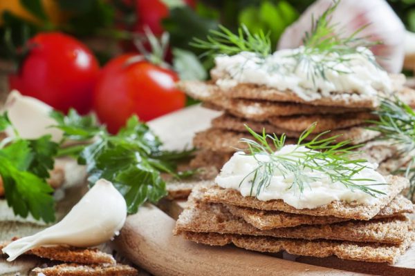 Rye crispbread with garlic sauce and herbs, selective focus