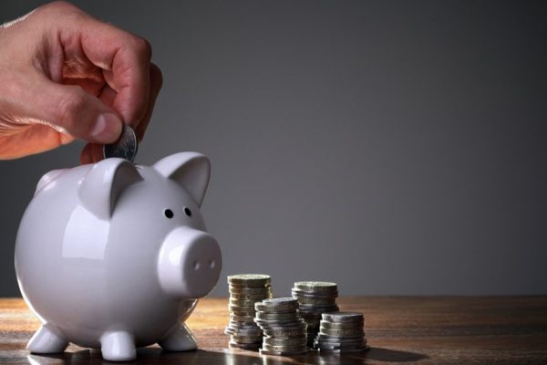 Inserting a coin into a piggy bank