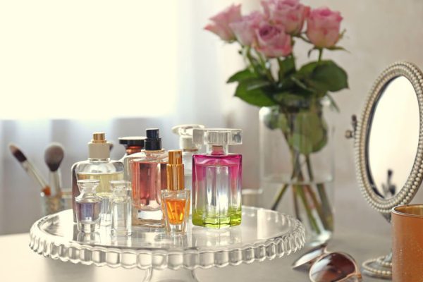 Stand with bottles of perfume on table