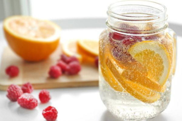 Refreshing water with fruits on table