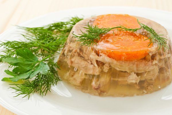 jellied meat and vegetables on a white plate