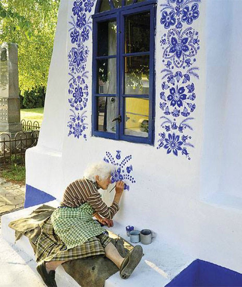 старушка расписывает стену