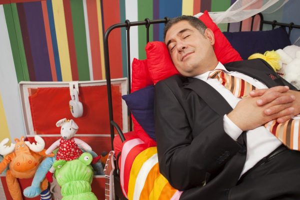 Mature man wearing full suit sleeping happly in children's bed - Relaxation - Humour -  Childish