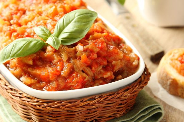 Eggplant salad (caviar) in bowl with basil leaves