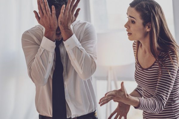 Family argument. Unhappy young woman shouting at her husband while having an argument with him