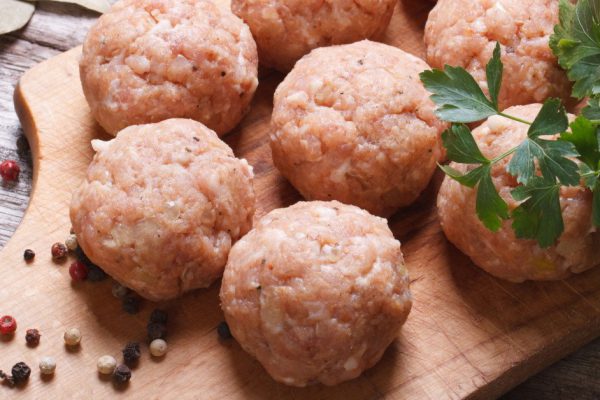 raw meatballs on a chopping board and ingredients. view from above. macro