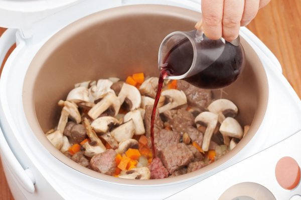 cooking beef stew with mushrooms and wine in Multicooker