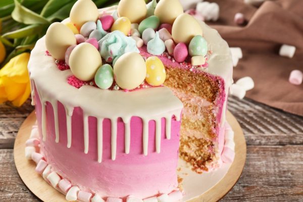 Sliced delicious Easter cake on wooden festive table