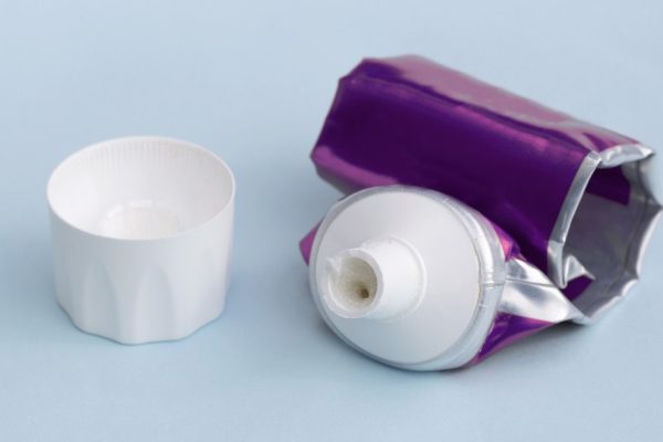 Empty tube of toothpaste on blue background