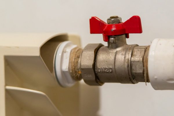 Water valve with red handle. Ball valve used in plumbing and heating systems. plumbing fittings.