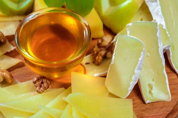 Cheese plate with honey nuts and grapes