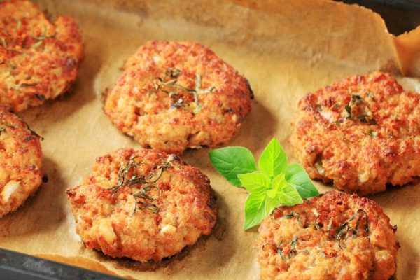 Vegetable burgers on baking parchment paper in baking pan