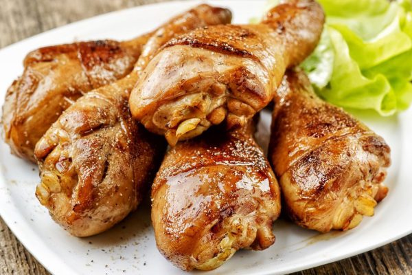 grilled chicken legs and lettuce on white plate