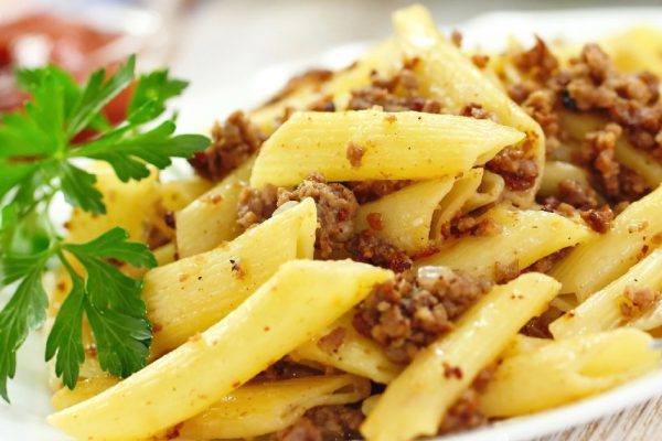 Pasta with fried meat, sauce and fresh vegetables
