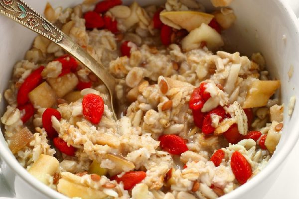 Oatmeal with goji berries, nuts and fruits for healthy vegan breakfast