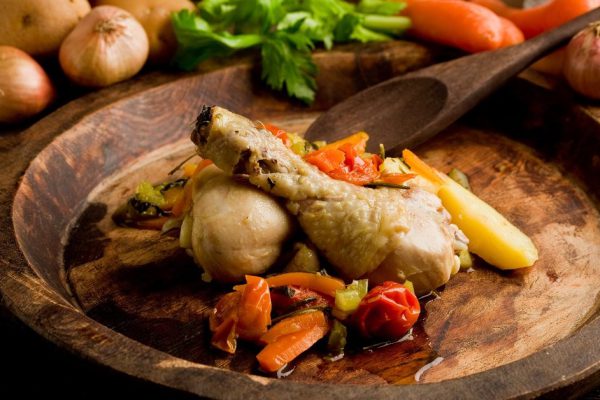 delicious stewed chicken with vegetables inside rustical wooden plate