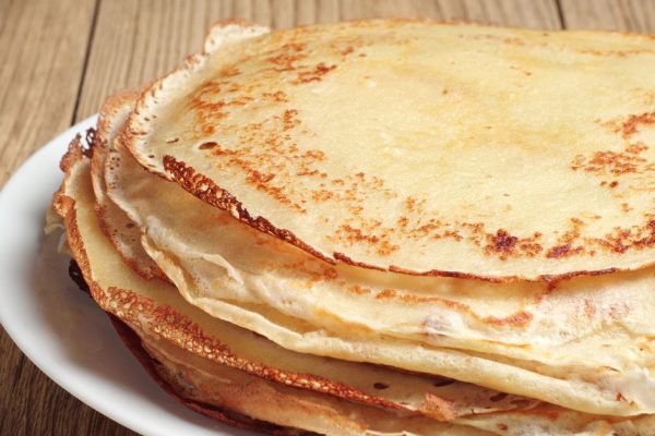 Stack of pancakes on wooden table closeup