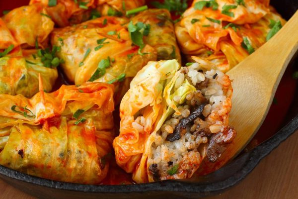 Stuffed cabbage rolls with rice and mushrooms in tomato sauce. Dolma, sarma, or golubtsy - traditional dish of many countries