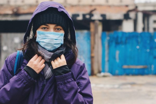 Coronavirus epidemic and quarantine. Woman wearing hygienic mask to prevent the virus. Air pollution. Outbreak Coronavirus. Person with face mask in quarantine city. Apocalypse.