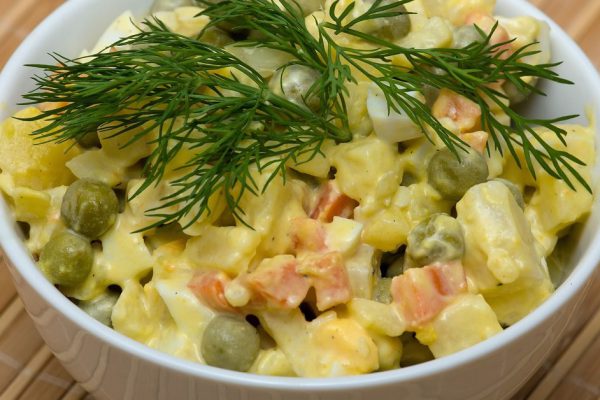 Russian traditional salad olivier in white plate